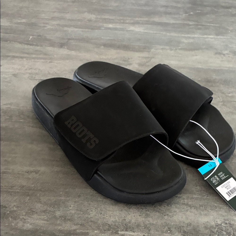 New  with tags Roots Black Slide Sandals with Embossed Logo